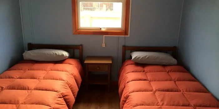 Habitación con dos camas y velador